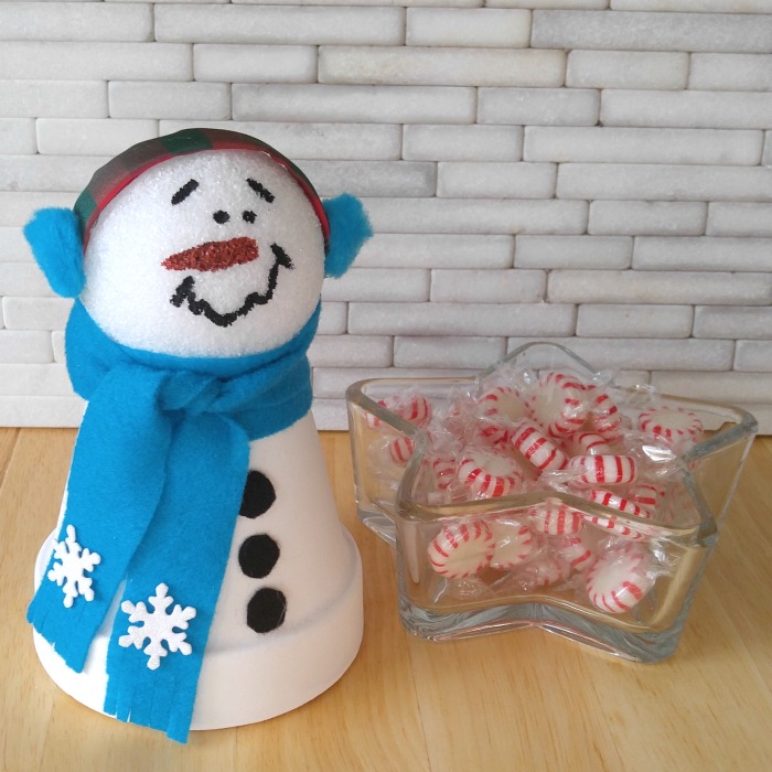 This clay pot snowman is right at home near a bowl of peppermints