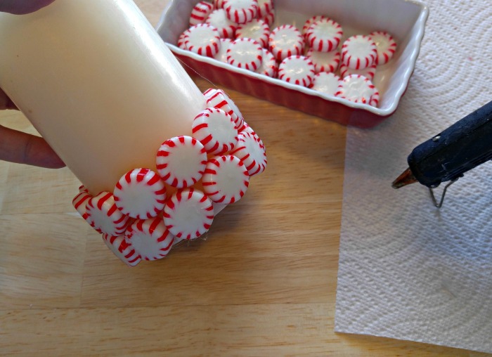 Hot glue the peppermints around the candle, staggering each row slightly.