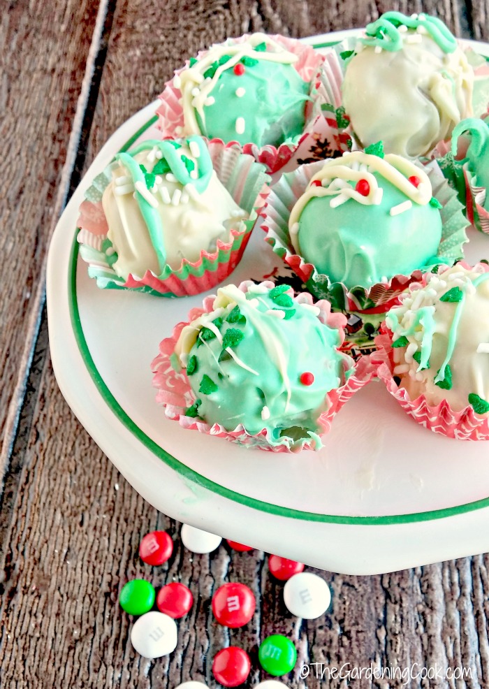 Funfetti peppermint Christmas truffles on a plate with loose m&ms in the foreground.