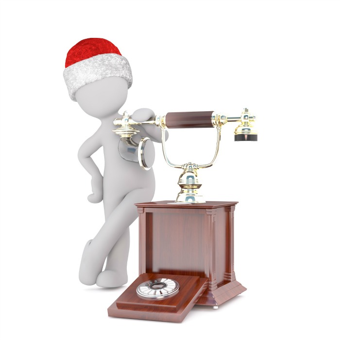 A mannequin wearing a Santa hat, standing next to an old rotary phone, getting ready to call the North Pole on Christmas Eve.