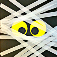 A DIY mummy door decoration made from poster board, streamers and Scotch tape.