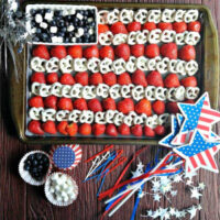 Patriotic fruit platter on a cookie sheet with 4th of July decorations.