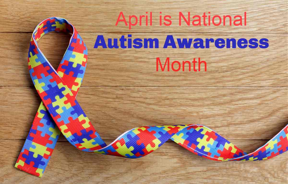 Multicolored jigsaw puzzle folded ribbon with words April is National Autism Awareness Month.