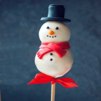 Snowman cake pop with a licorice hat and scarf.