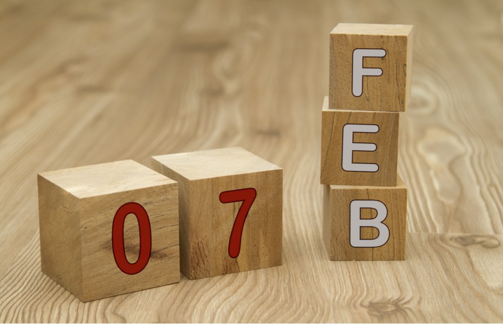Blocks that say Feb in white lettering and 07 in red lettering on a wooden table top.