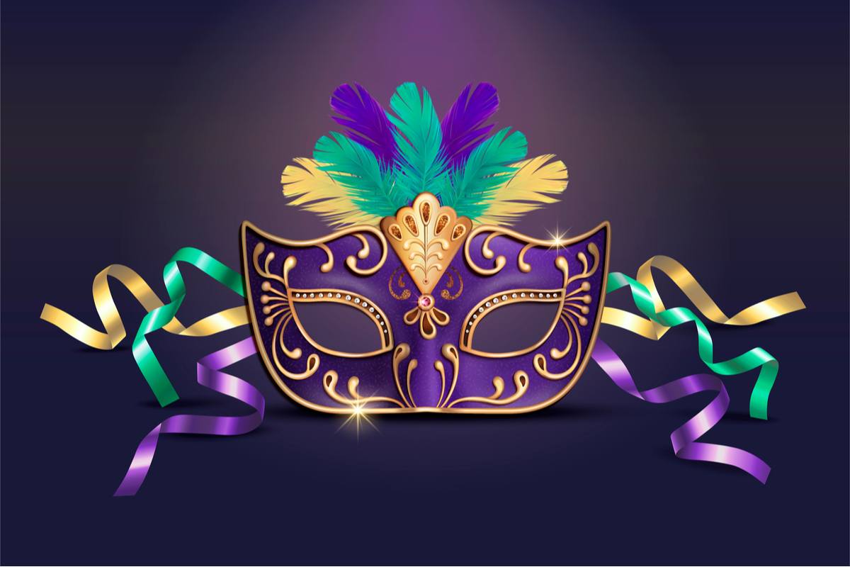 A purple Mardi Gras mask with feathers and ribbons in the Mardi Gras colors: green, gold and purple.