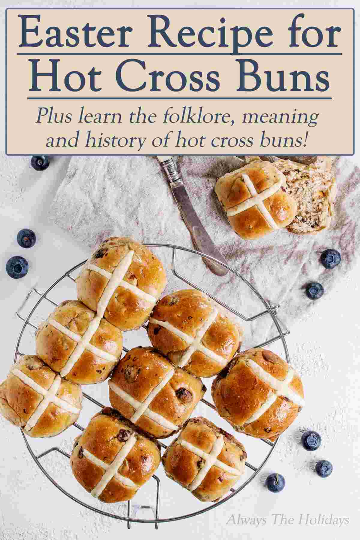 A cooling rack of hot cross buns with a text overlay that reads "Easter Recipe for Hot Cross Buns, plus learn the folklore, meaning and history of hot cross buns".