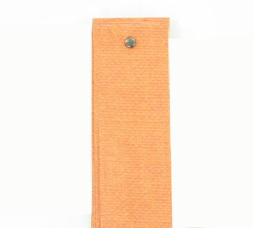 A stack of orange scrapbook paper cut into strips for a paper strip pumpkin, fastened with a small brad.